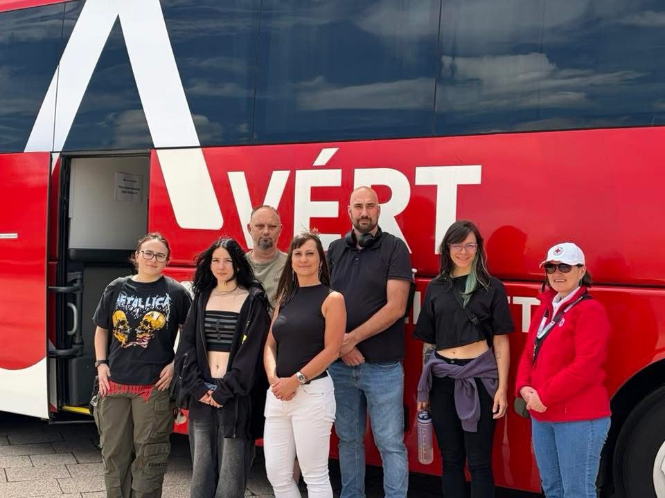 Véradók és önkéntesek csoportja a véradóbusz előtt a Metallica-koncerthez kötődő akción